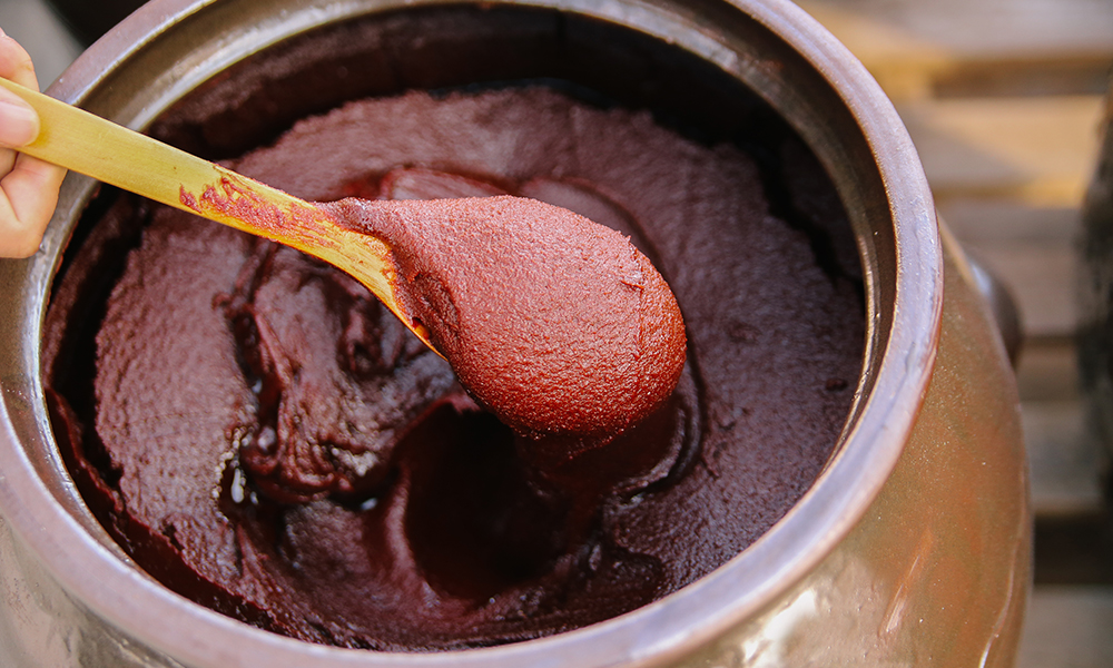 Gochujang fermenting in a traditional onggi pot